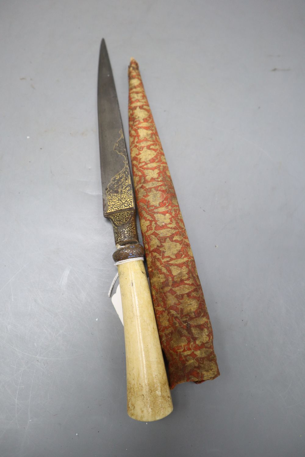 A Persian kard, bolsters and root of blade gold-inlaid with inscriptions, walrus tusk hilt, length blade point to end of handle 34cm